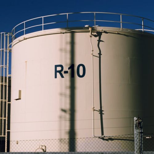Large industrial storage tanks under blue skies, highlighting metal structures.