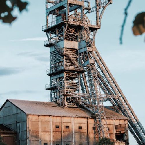 Rusty industrial mining tower in Heusden-Zolder, Belgium during daylight.
