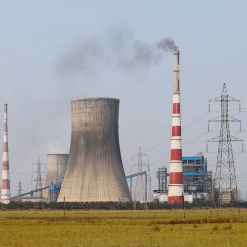 Smokestacks and a cooling tower emit smoke at a power plant in Vijayawada, India.